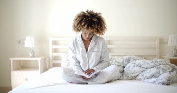 Žena čte knihu na posteli — Stock video