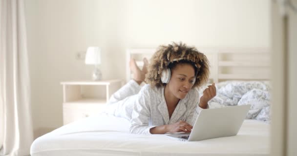 Vrouw met behulp van laptop en muziek luisteren — Stockvideo