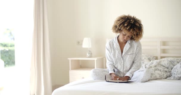 Женщина пишет дневник в постели — стоковое видео
