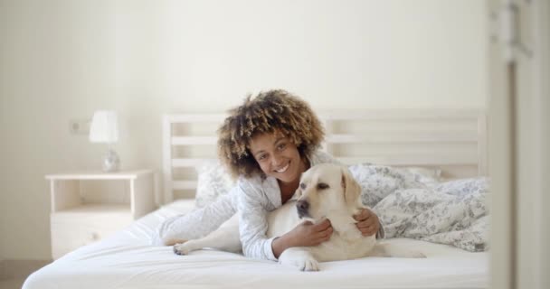 Mujer sosteniendo perro en cama — Vídeos de Stock