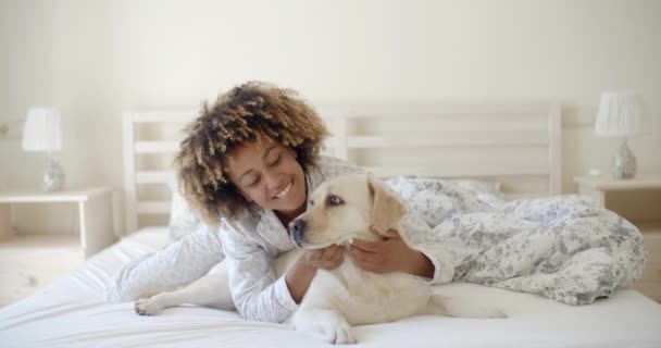 Woman holding dog on bed — Stock Video