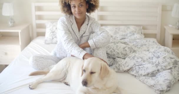 Vrouw en hond rusten in bed — Stockvideo