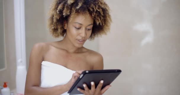 Жінка використовує планшетний комп'ютер у ванній — стокове відео