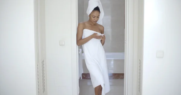 Woman using mobile phone in bathroom — Stock Photo, Image