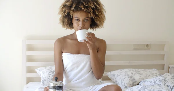 침대에서 커피를 마시고 있는 여자 — 스톡 사진