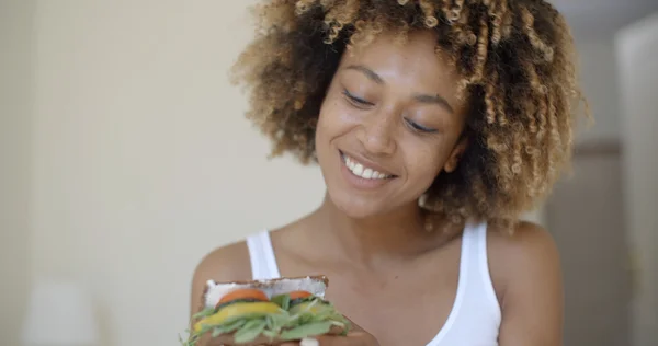 Женщина в постели и держит здоровый сэндвич — стоковое фото
