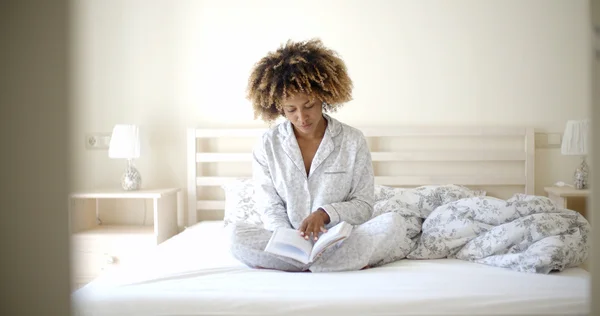Kobieta czytanie książki na łóżku — Zdjęcie stockowe