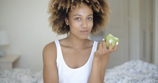 Mujer sentada en la cama y comiendo manzana —  Fotos de Stock