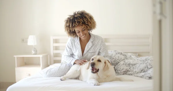 Woman and dog resting in bed — Stock Photo, Image