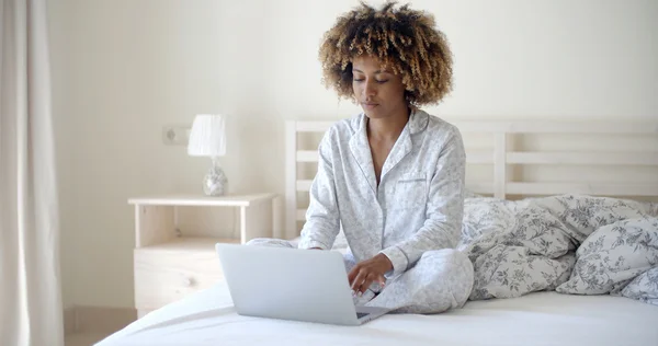 Vrouw met laptop op haar bed — Stockfoto