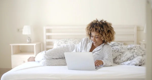 ベッドの上でノートパソコンを使う女 — ストック写真