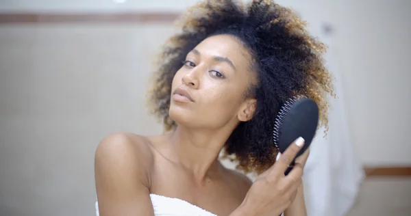 Mulher escovando o cabelo no banheiro — Fotografia de Stock