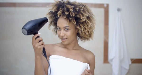 Γυναίκα κρατώντας Στεγνωτήρας μαλλιών και στέγνωμα μαλλιών — Φωτογραφία Αρχείου