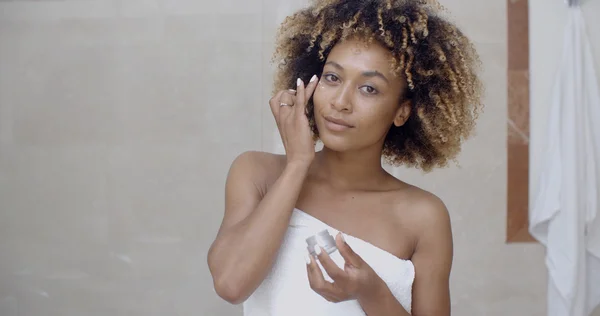 Mujer aplicando crema hidratante cosmética — Foto de Stock