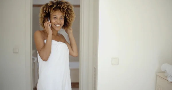 Женщина в белом полотенце разговаривает по телефону — стоковое фото