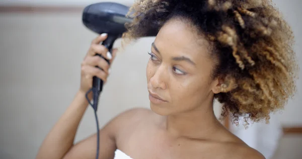 Mujer sosteniendo secador de pelo y secando el cabello — Foto de Stock