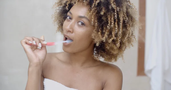 Mujer cepillarse los dientes en el baño — Foto de Stock