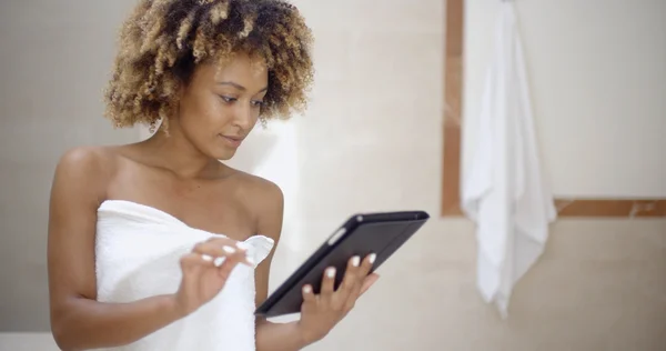 Mujer que usa tableta en el baño —  Fotos de Stock
