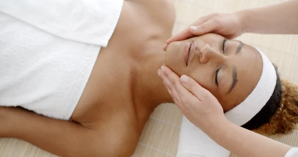 Терапевт масажує жіноче обличчя — стокове фото