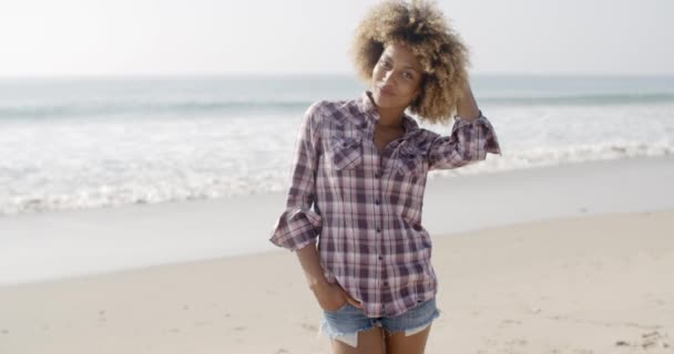 Lässige junge Frau steht am Strand — Stockvideo