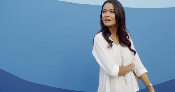 Kobieta stojąc w pobliżu niebieską ścianą — Zdjęcie stockowe