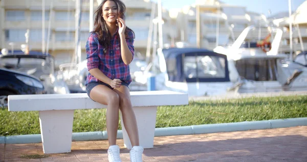 Woman sitting on bench in harbor — Stock Photo, Image