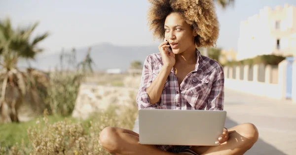 Student praten over telefoon en met behulp van laptop — Stockfoto