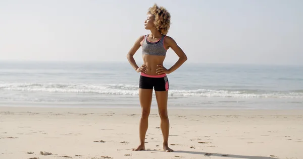 Mujer usando ropa deportiva de pie en la playa — Foto de Stock
