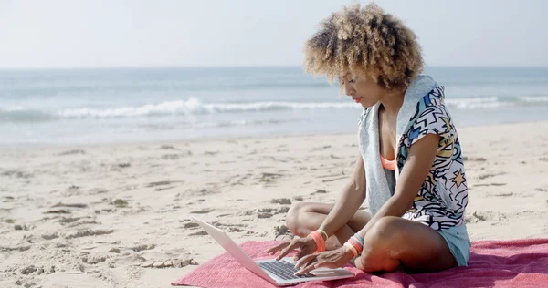 Flicka som arbetar med laptop på stranden — Stockfoto