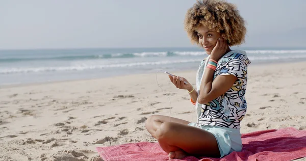 Жінка слухає музику на пляжі — стокове фото