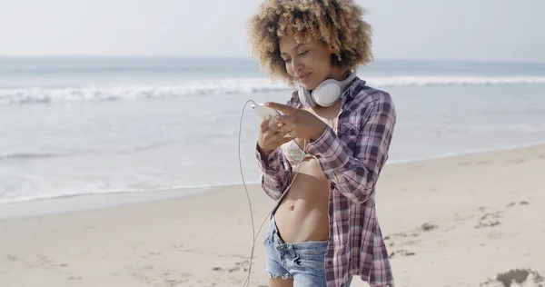 Mujer con auriculares en la playa — Foto de Stock