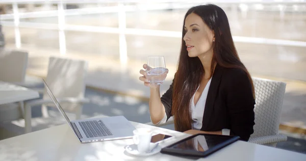 Geschäftsfrau trinkt Wasser und arbeitet im Restaurant — Stockfoto