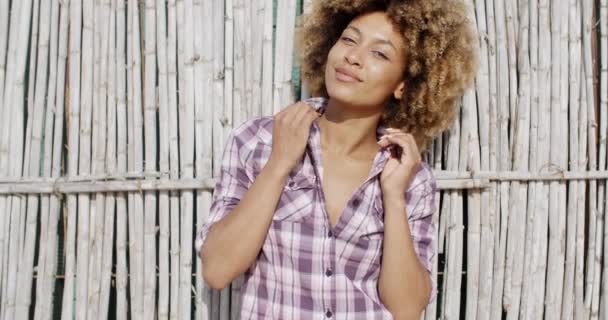 Meisje glimlachen over reed muur — Stockvideo