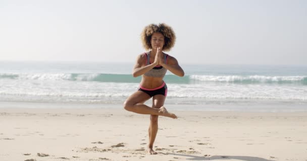 Vrouw doet yoga oefening op het strand — Stockvideo