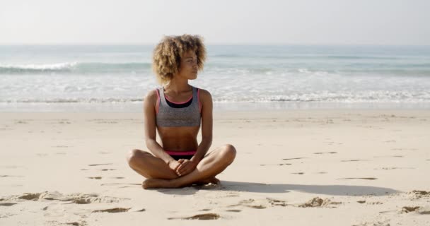 Menina sentada na posição de lótus na praia — Vídeo de Stock