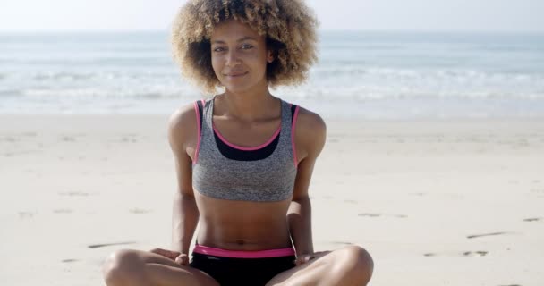 Mujer en forma sentada en la playa — Vídeos de Stock