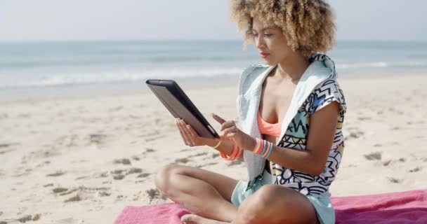 Mujer usando tableta táctil en la playa — Vídeo de stock