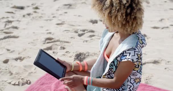 Mujer usando tableta táctil en la playa — Vídeo de stock