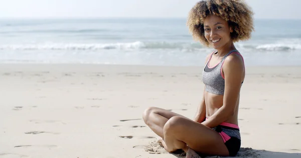 Mulher em sportwear relaxante na praia — Fotografia de Stock