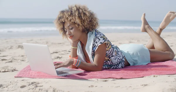 Жінка на пляжі використовує комп'ютер — стокове фото