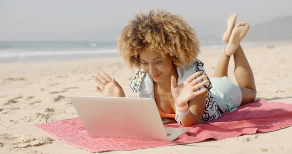 Kvinnan talar med vän online på stranden — Stockfoto