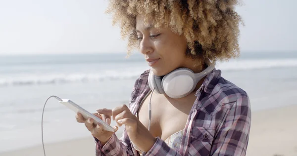 Chica escuchando música en la playa — Foto de Stock