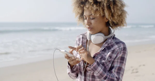 Chica escuchando música en la playa — Foto de Stock