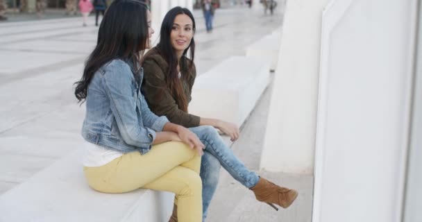 Women relaxing on bench on city promenade — Stockvideo