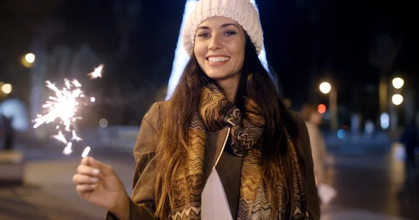 Woman celebrating with sparkler outdoors — Zdjęcie stockowe