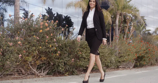 Businesswoman striding along sidewalk — Stockfoto
