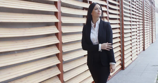 Businesswoman walking alongside commercial building — Stok fotoğraf