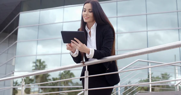 Businesswoman standing on stairway and using tablet — 图库照片