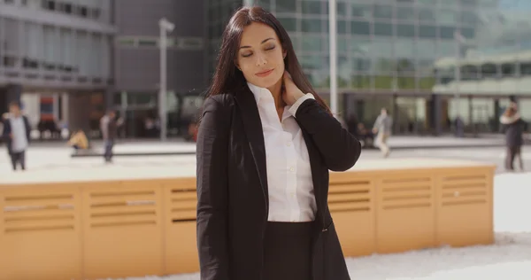 Businesswoman rubbing neck to relieve tension — Stockfoto