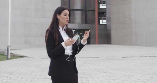 Mujer de negocios tomando llamada usando tapones para los oídos — Vídeos de Stock